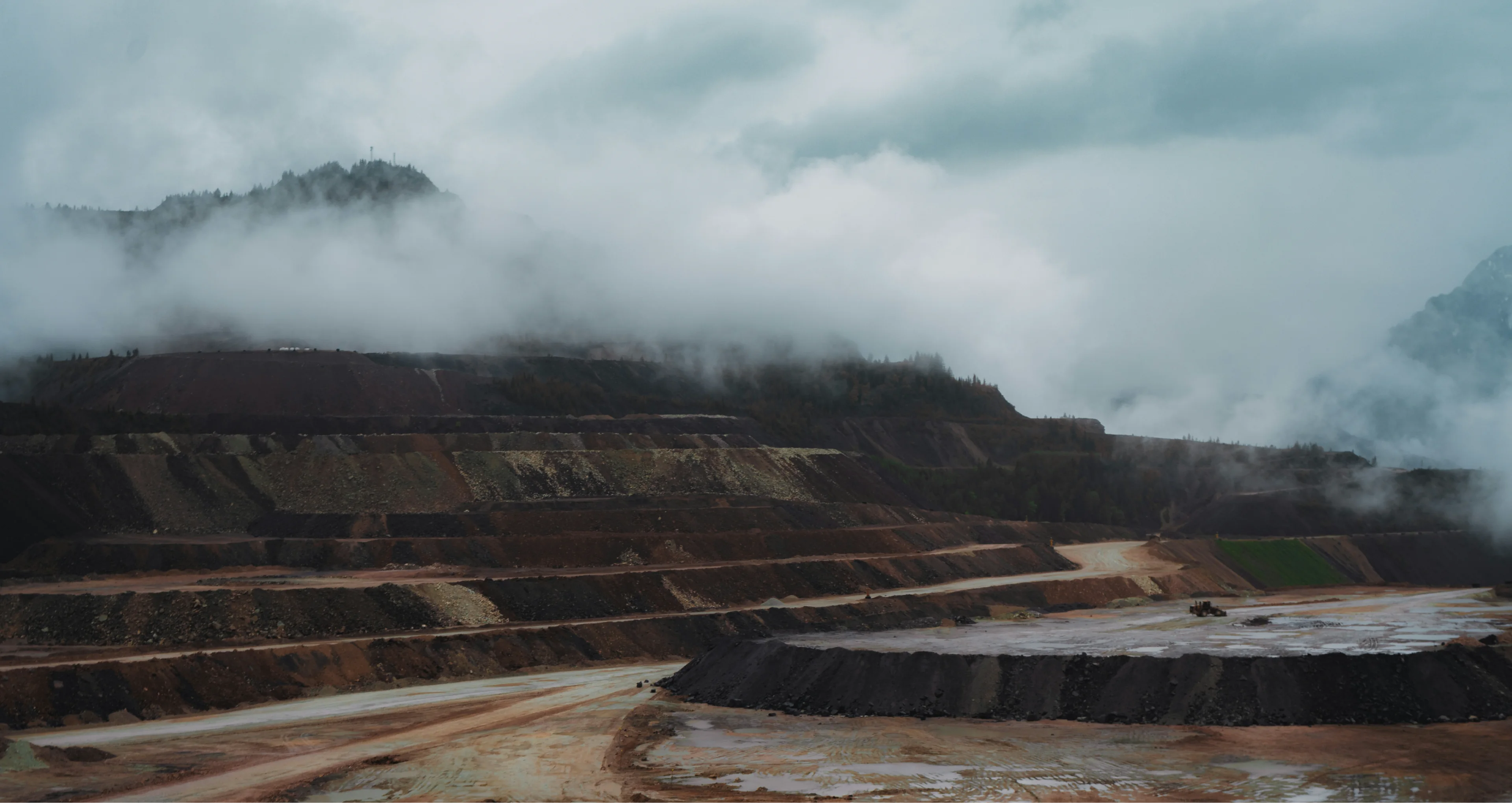 Electrified mining site beneath low clouds